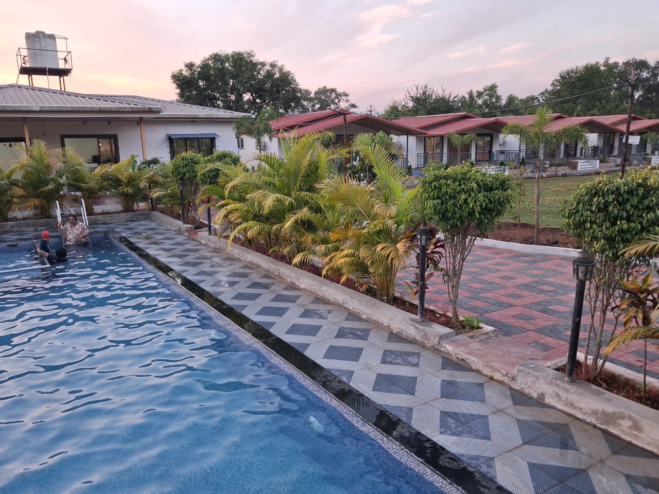 Nature Bliss Karjat farmstay grounds at dusk